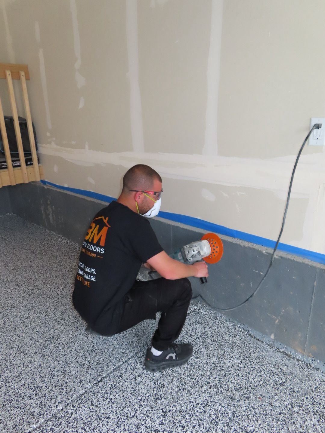 BM Epoxy Floors owner standing in completed flake garage